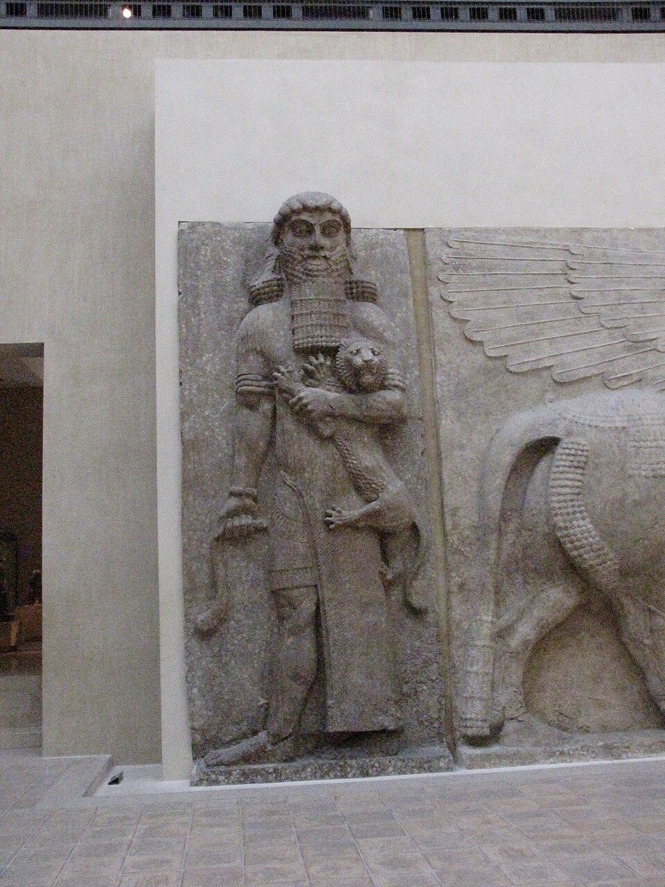 Colossal Neo-Assyrian stone relief of Gilgamesh holding a lion